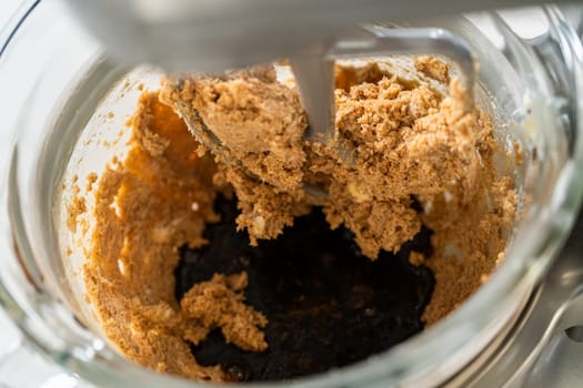 Adding the molasses and egg mixture into the creamed butter and sugar in preparation for Chocolate Gingerbread Cookie Dough. This dark, rich molasses will give the dough a deep flavor and color.