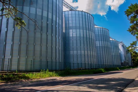 Industrial vertical stainless steel liquid tanks outdoors. Metal tank for liquid. Stainless steel tank. Industrial equipment of the enterprise. Food industry. Production cycle.