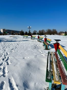 a walk along the embankment in winter and colorful benches