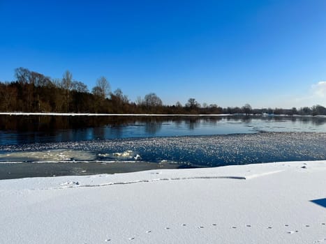 embankment of the river in winter, on the other side of the oak forest