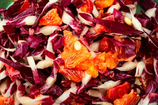Fresh red chicory salad with orange on a plate. Vegetarian meal. Copy space