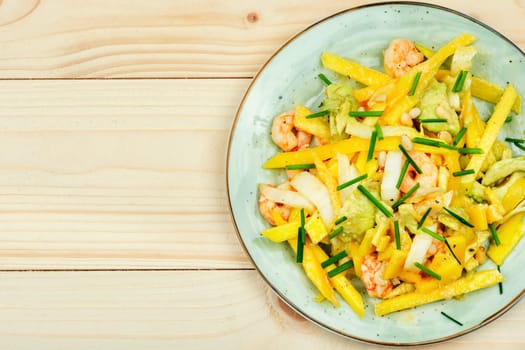 Delicious salad of mango, avocado, shrimp and pine nuts served on plate.