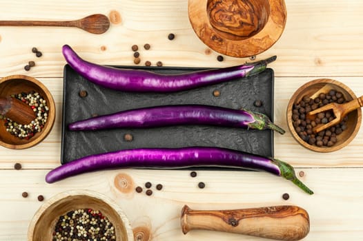 Raw small eggplants on a wooden table. Diet menu concept. Top view