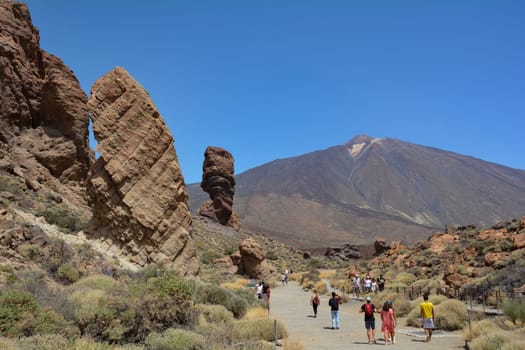 Teide National Park, Tenerife, Spain August 13, 2022 - The bizarrely shaped Roque Cinchado rock of volcanic rock in Teide National Park on the Canary island of Tenerife, Spain. With views of Mount Teide and blue skies