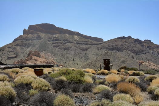 Teide National Park, Tenerife, Spain August 13, 2022 - Parking lot with sculpture at the Parador de Cañadas del Teide excursion restaurant and hotel at Roques de García in the national park on the Canary Island of Tenerife