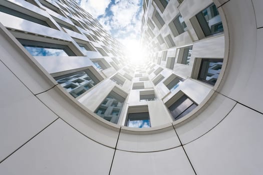 View upwards, along the facade of a skyscraper in Berlin with strong backlight by the sun