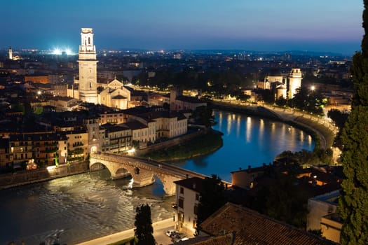 Verona, Italy - June 2022: panorama by night. Illuminated cityscape with scenic bridge