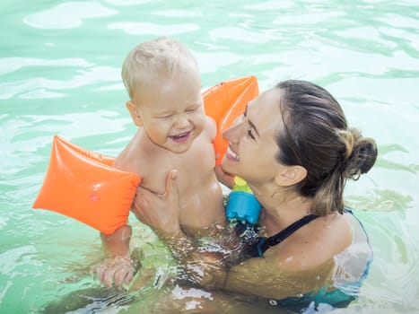 Baby and mother in swimming pool