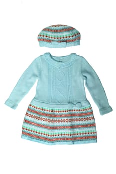 Clothes for children. A beautiful blue knitted bright baby girl dress and hat with colorful pattern isolated on a white background. Kids fashion for spring and autumn.