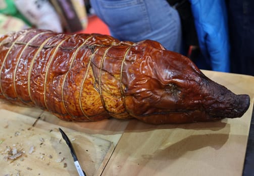 Baked suckling pig whole on a wooden board