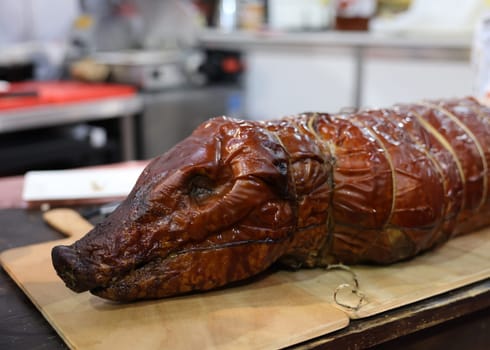 Baked suckling pig whole on a wooden board