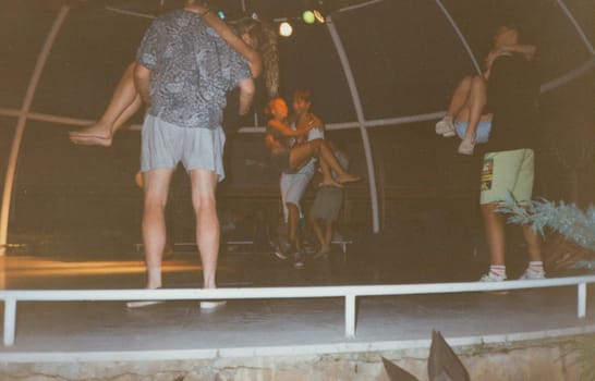 THE CZECHOSLOVAK SOCIALIST REPUBLIC - CIRCA 1980s: Retro photo shows people during summer dancing party. Vintage color photography. Circa 1980.