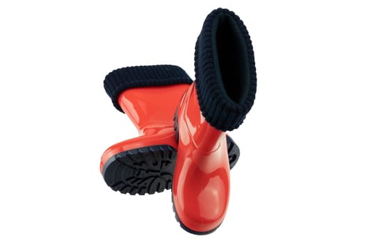 Childrens shoes and boots. Closeup of seasonable red rubber boots or gumboots isolated on a white background. Clipping path. Kids shoe fashion.
