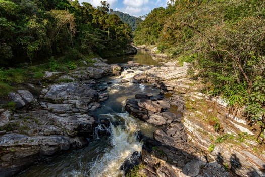 Madagascar mountain river in tropical forest on the hills. Sunny day. Ranomafana national park. Madagascar wilderness landscape