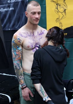 Krakow, Poland -  June 11, 2022: Unidentified  participant at 15th Tattoofest Convention in Cracow. One of the most prestigious tattoo festivals. Tattoo artist at work.