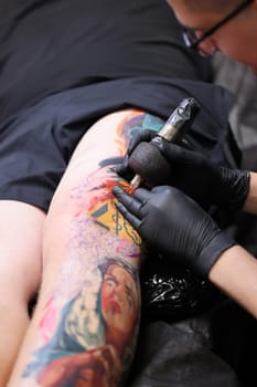 Krakow, Poland -  June 11, 2022: Unidentified  participant at 15th Tattoofest Convention in Cracow. One of the most prestigious tattoo festivals. Tattoo artist at work.