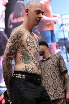 Krakow, Poland - June 11, 2022: Unidentified participant during the contest for the best tattoo at the 15th Tattoofest Convention in Cracow. One of the most prestigious tattoo festivals.