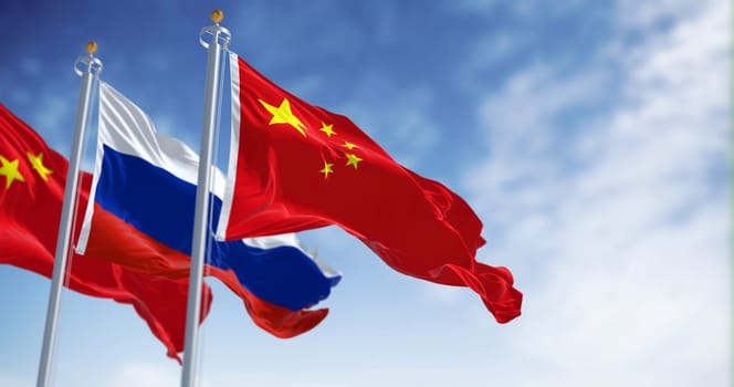 The flags of China and Russia waving in the wind on a clear day. International relations and diplomacy. 3d illustration render. Selective focus. Fluttering textile