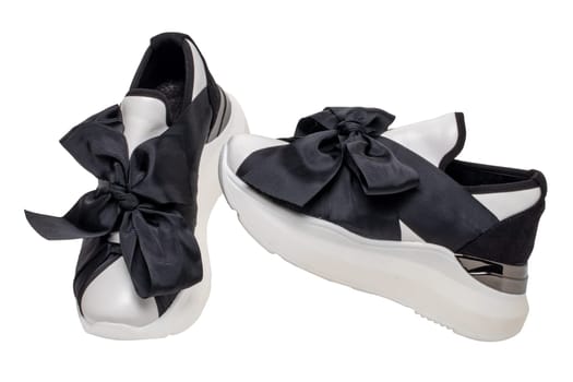 White sneaker isolated. Close-up of a pair black white elegant stylish female leather high-heeled sport shoes isolated. Clipping path. Womens shoe fashion. Modern design footwear for workout.