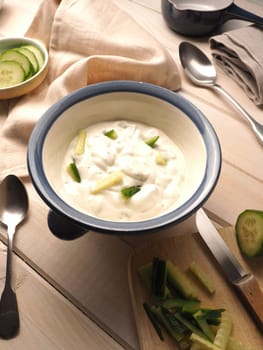 Tasty organic garlic sauce with cucmber on a rustic wooden table