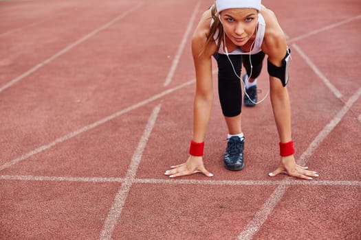 Fit girl in activewear standing at start line ready to run
