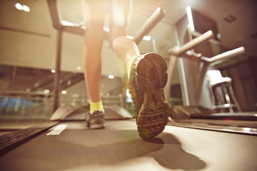 Legs of fit young woman running on treadmill