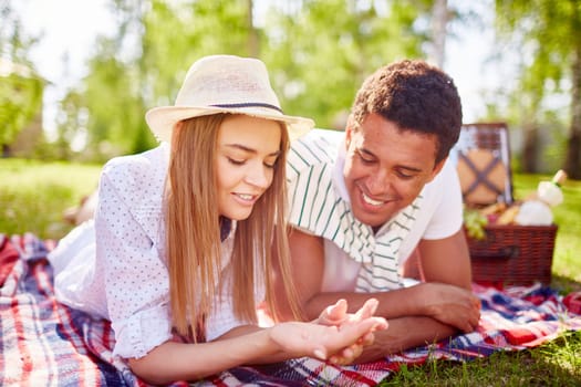 Happy young couple relaxing in park on weekend