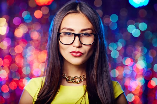 Asian girl in eyeglasses and perfect makeup looking at camera