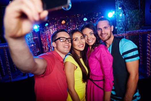 Group of happy friends making selfie in nightclub