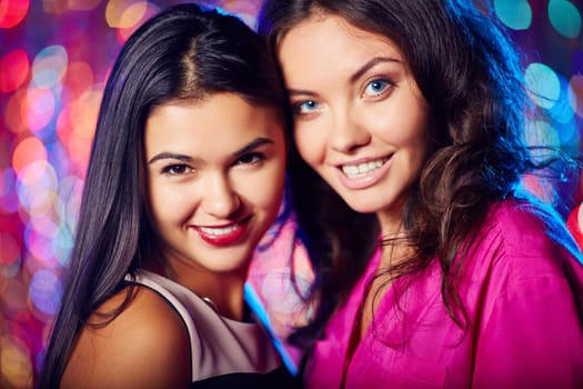 Charming girls looking at camera at party