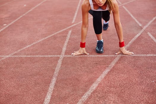 Sporty female on racetrack ready to run