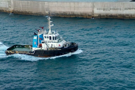 Civitavecchia. Italy - February 18, 2025: The tugboat Vastaso, seen navigating near a port, demonstrates essential maritime operations. Ideal for content involving nautical and industrial themes.