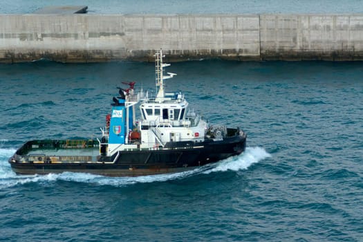 Civitavecchia. Italy - February 18, 2025: A close-up of the tugboat Vastaso on the sea, emphasizing its robust design and role in maritime logistics. Perfect for content related to sea transportation.