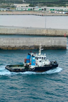 Civitavecchia, Italy - February 18, 2025: Tugboat Vastaso, registered in Naples, sails near port. Detailed view of its industrial design and maritime functionality. Transport and industry topics.