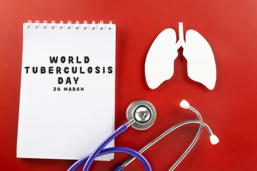 World Tuberculosis Day. Overhead lungs paper symbol, medical stethoscope and notebook paper on red background, lung cancer awareness, copy space concept of world TB day