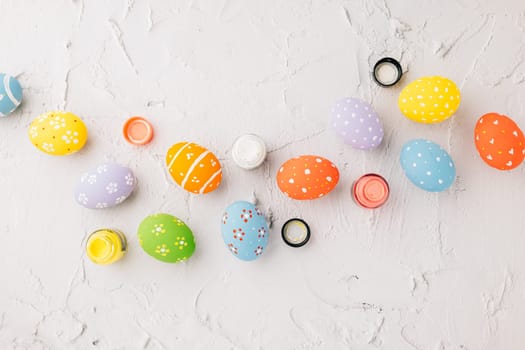 Easter Day Concept. colored multi-colored and paints brush painting easter eggs, colorful paints and paint brushes isolated on white cement background with copy space for text