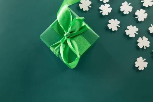 Happy St Patricks Day decoration background. above view gift box green clover leaves festive decor, shamrocks leaves holiday symbol with copy space on green background, Banner greeting card concept