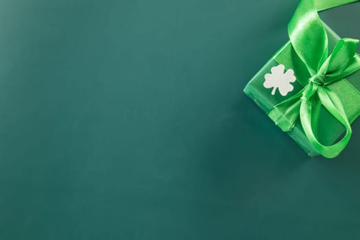 Happy St Patricks Day decoration background. above view gift box green clover leaves festive decor, shamrocks leaves holiday symbol with copy space on green background, Banner greeting card concept