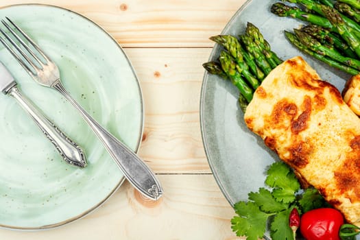Egg omelet cooked with green asparagus on rustic wooden table