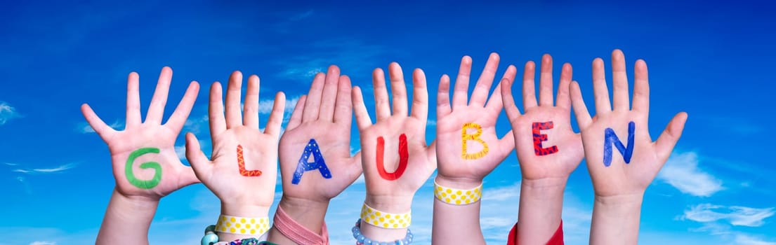 Children Hands Building Colorful German Word Glauben Means Believe. Blue Sky As Background.