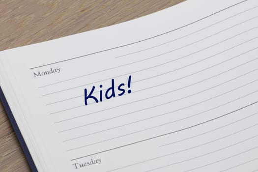 A Kids reminder note in blue ink in a diary page