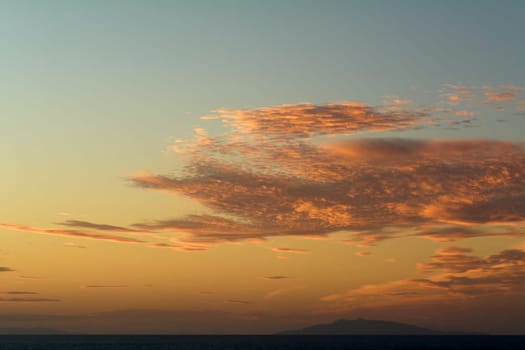 A stunning display of clouds at sunset, with orange and yellow hues illuminating the horizon, creating a serene and peaceful atmosphere. Ideal for nature and landscape content.