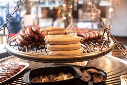 Grilling sausages on barbecue grill at a food stall of Christmas market