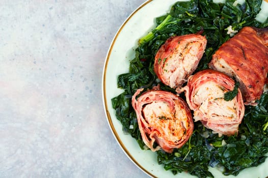 Grilled chicken fillet roll and fried spinach. Copy space