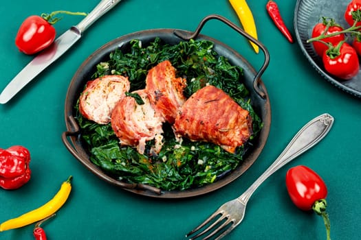 Grilled chicken fillet roll and fried spinach. Copy space