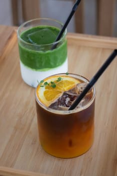 Iced matcha greentea and iced black orange coffee on wooden table, stock photo