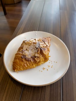 Fresh baked almond croissant and coffee breakfast, stock photo