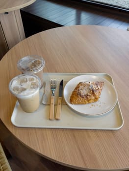Fresh baked almond croissant and coffee breakfast, stock photo