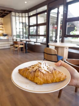 Fresh baked almond croissant and coffee breakfast, stock photo