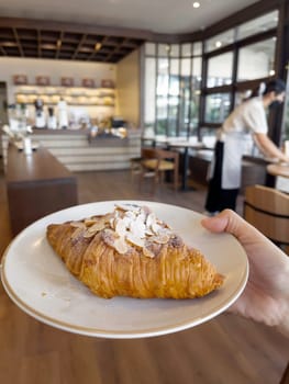Fresh baked almond croissant and coffee breakfast, stock photo
